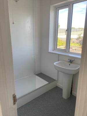 Compact shower room finished with new tray, basin and flooring